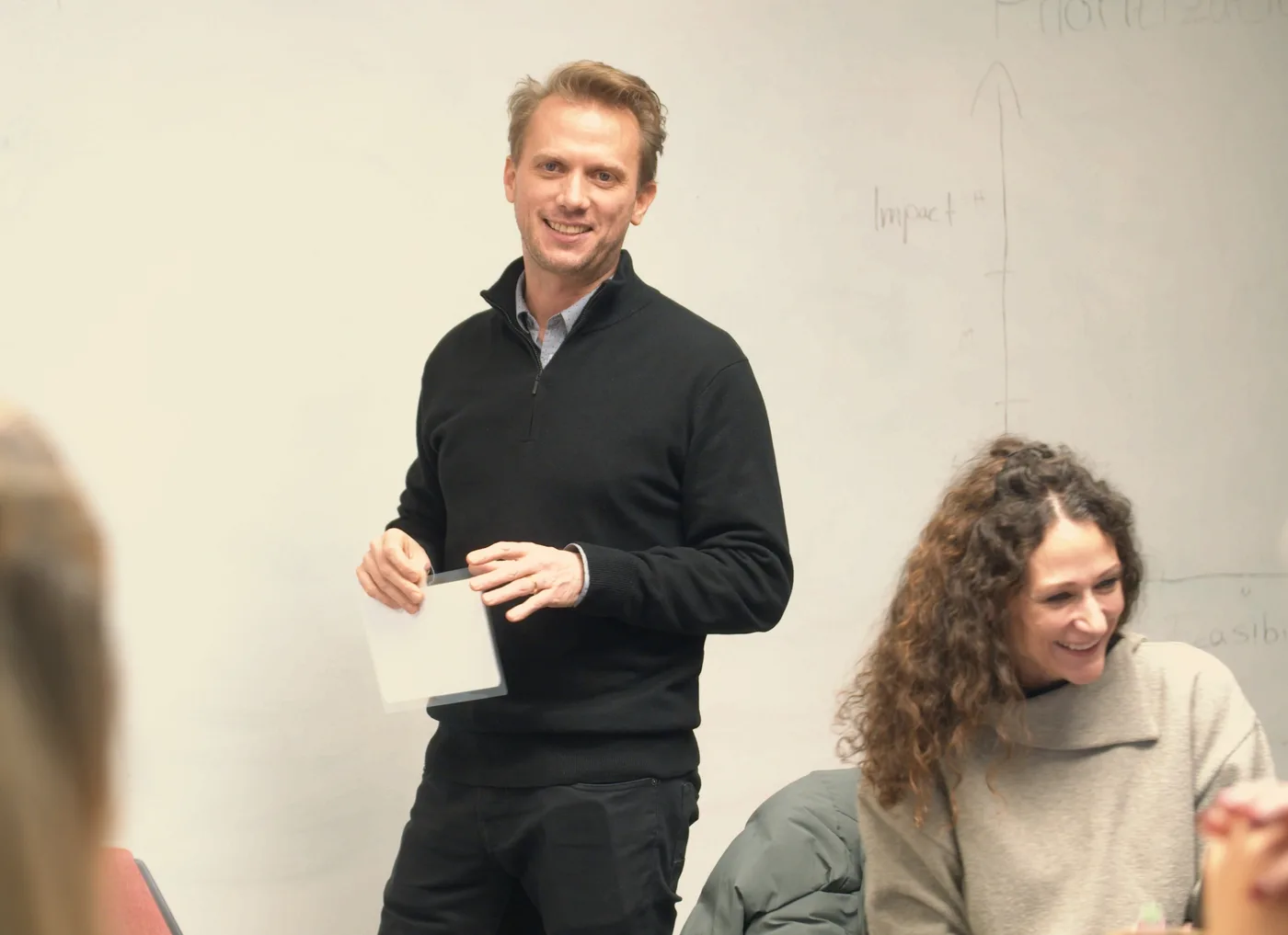 Marc Weimer-Hablitzel stehend in einer Workshop-Situation, neben ihm eine lachende Frau